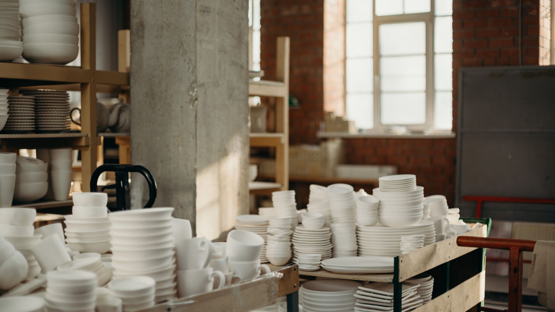 Handcrafted ceramic bowls and plates in a rustic workshop ambiance.